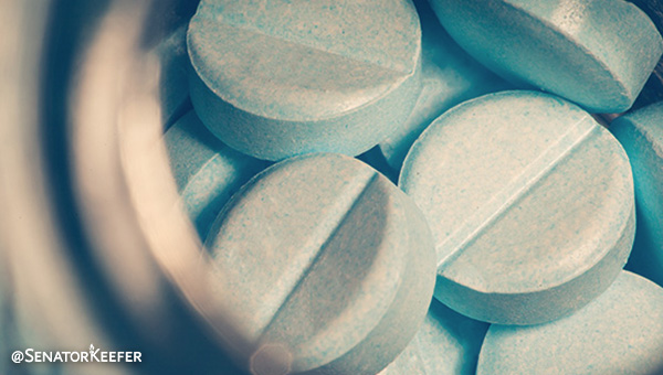Several blue and white pills in a container.