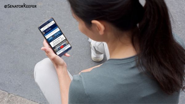 Person holding a phone and looking at screen.