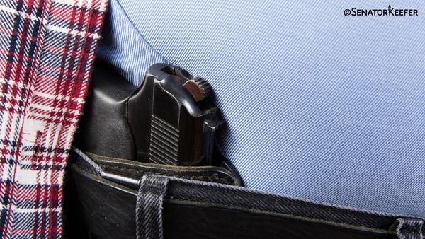 pistol tucked in a pants belt.