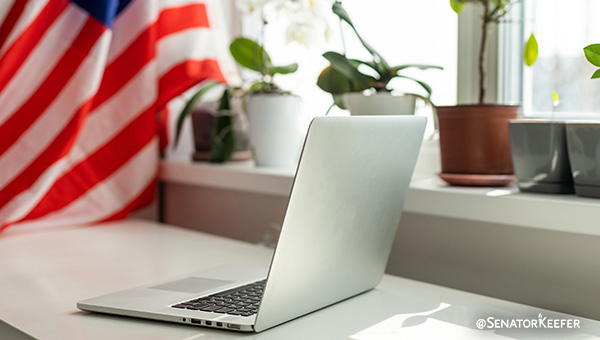 A computer sitting on a desk with the American flag in the background.
