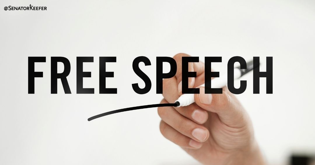 A graphic showing a hand holding a marker writing the words “Free Speech”.