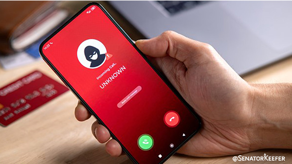 Mobile phone screen displaying an incoming call labeled 'Unknown' with a warning icon, shown in a person's hand.