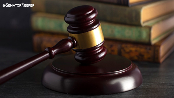 A picture of a gavel on a desk with books.